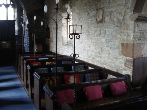 The hour-glass holder stands beside the frontmost pew